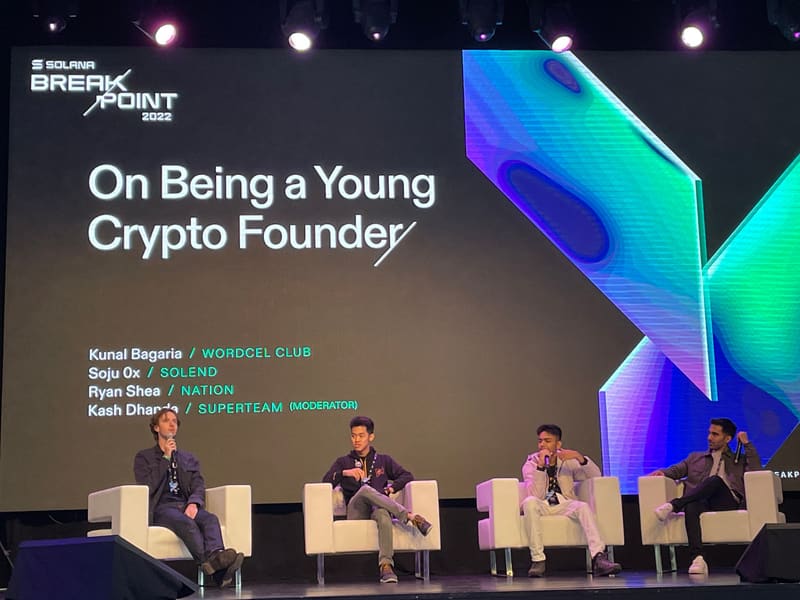 Four people seated on stage under a screen reading On Being a Young Crypto Founder, which lists Kunal Bagaria of Wordcel Club, Soju of Solend, Ryan Shea of Nation, and Kash Dhanda of Superteam as moderator.